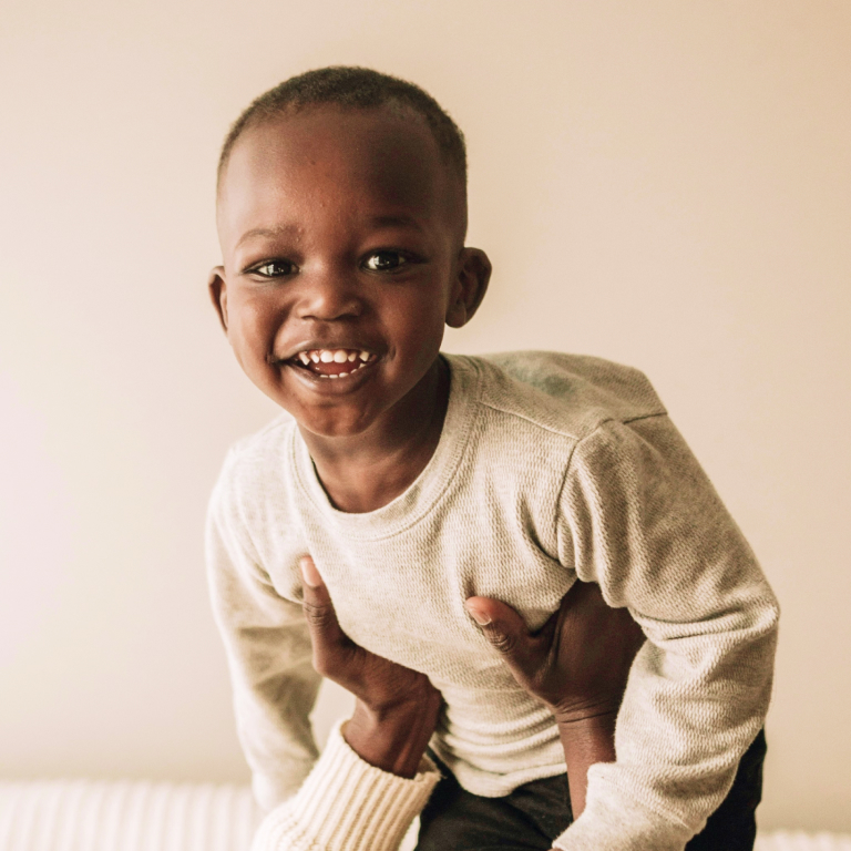 Young Black boy smiling while being held in air