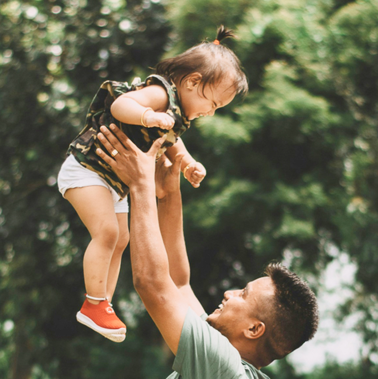 Man holding his infant daughter in the air