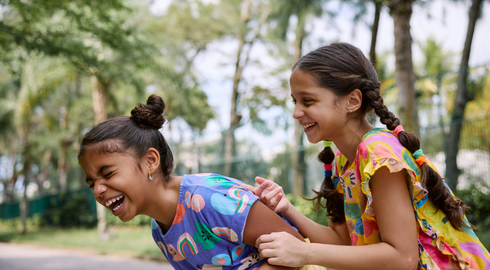 Three Young Girls Smiling While Sitting Around a Table