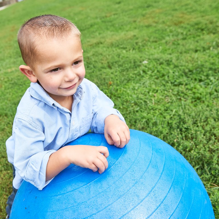 Little Boy Leaning on Exercise Ball