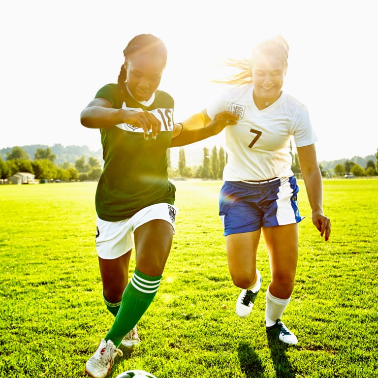 Two Teen Girls Playing Soccer Together Outside