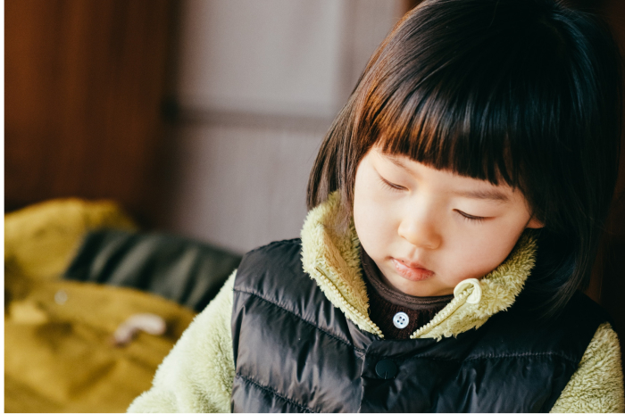 Young Asian Child Looking Down While Drawing