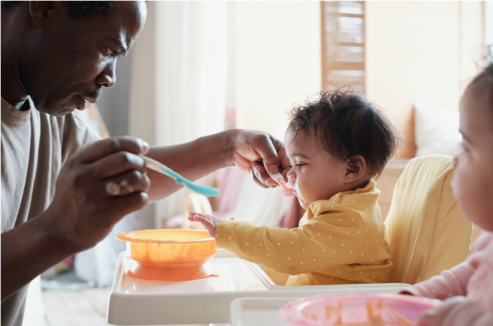 Black Father Feeding Baby in Highchair