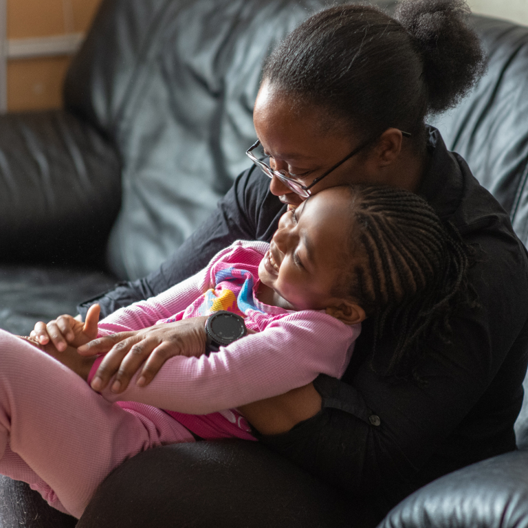 Young Black Girl Laughing While Sitting on Mother's Lap