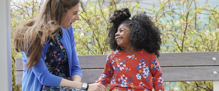 social worker and child sitting outside talking